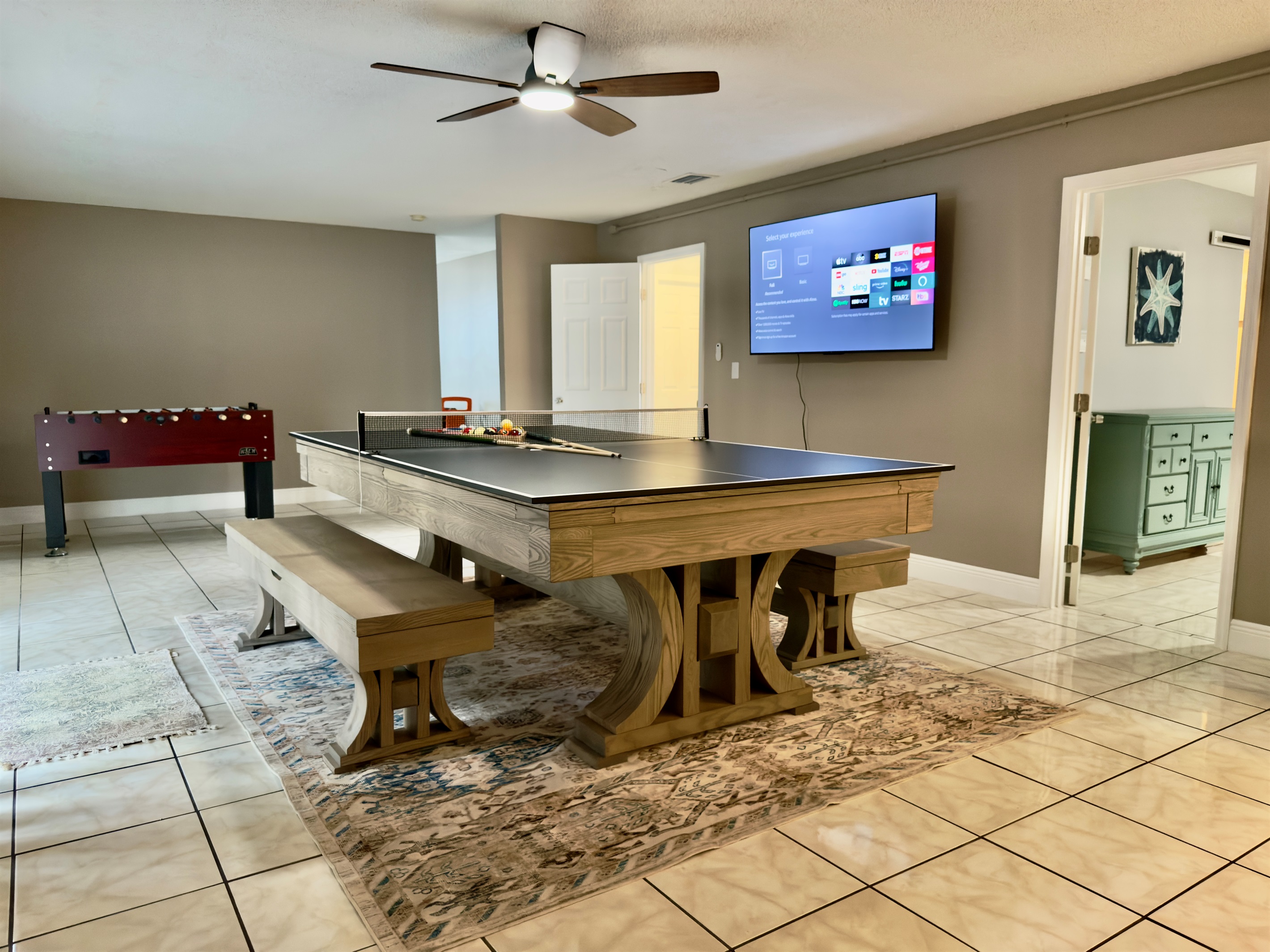 Mounted on the wall is a large flat-screen Smart TV, equipped with all the streaming favorites including Netflix, Hulu, Disney+, and more.