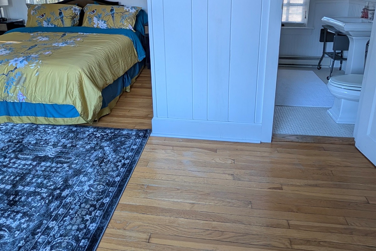 Private bedroom with convenient en-suite bathroom access and warm hardwood floors.