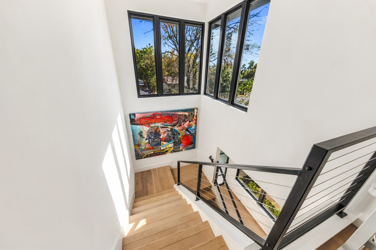 Bright stairwell framed by oversized windows and bold, colorful artwork