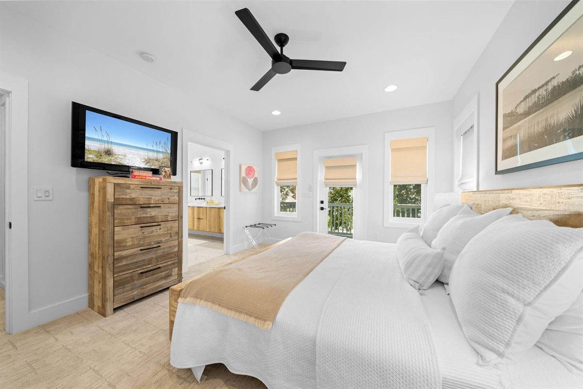 Secondary Suite offers another oversized bedroom with a king bed, dresser, wall mounted Smart TV, en-suite bath, private porch access, and a large closet.