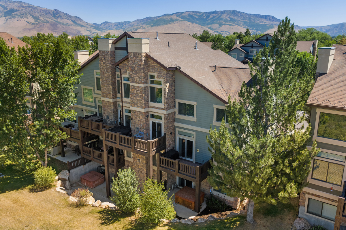 Exterior view of the building featuring private decks and mountain surroundings.