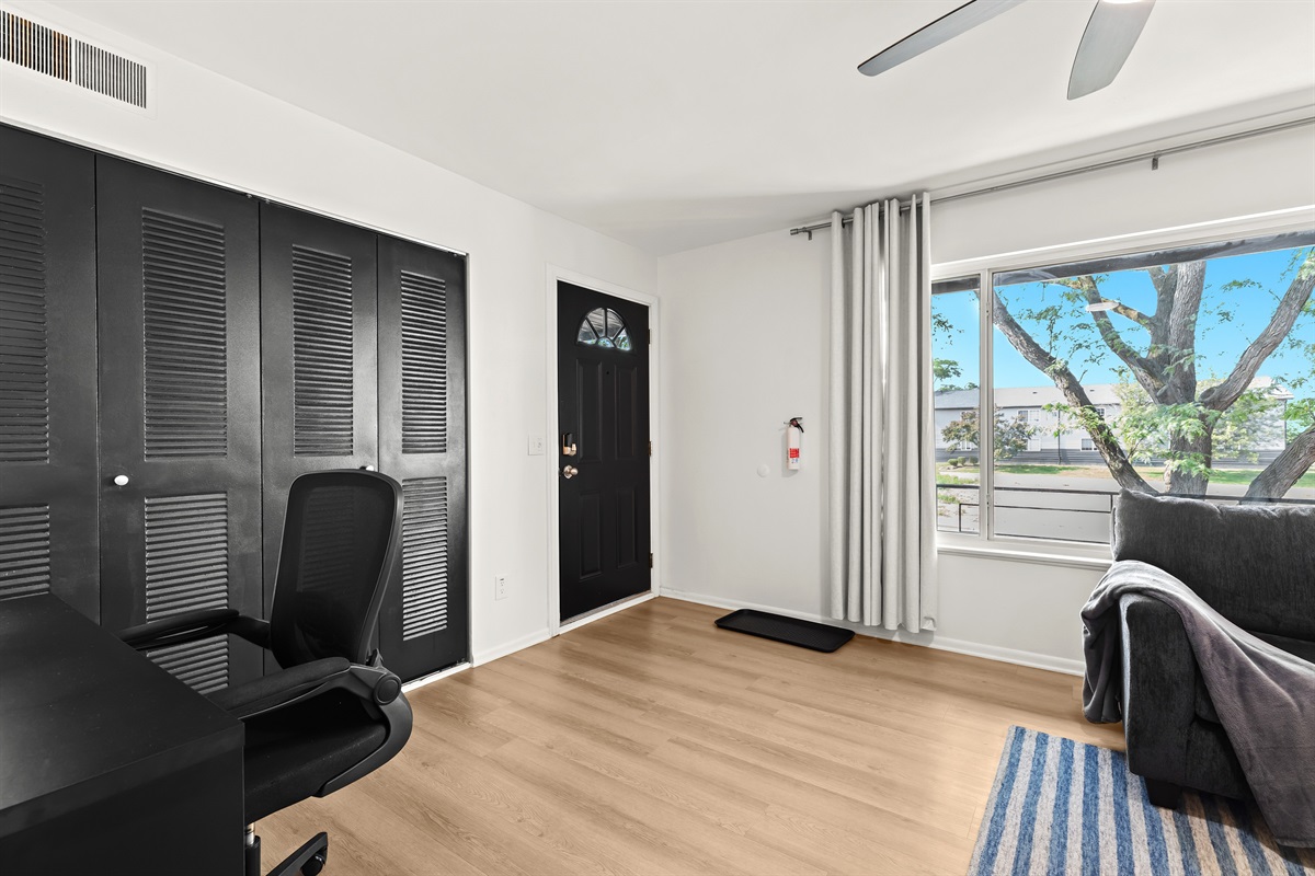 Bright entryway and workspace with blackout curtains and access to the patio.