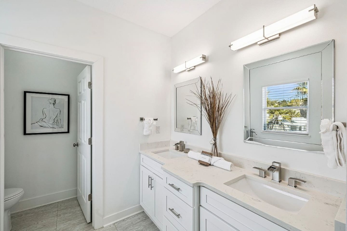 Primary en-suite bathroom featuring a spacious dual-sink vanity and bright modern lighting for effortless group get-ready mornings