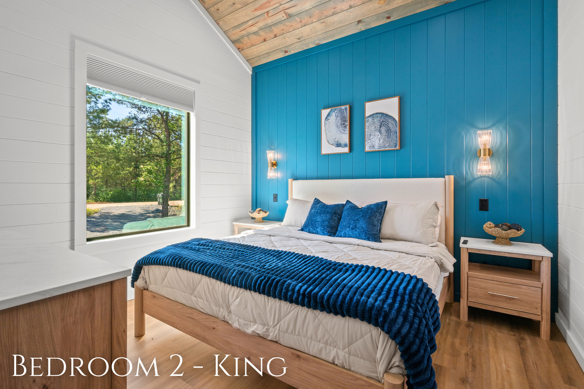 Rich blue accents, soft lighting, and cozy textures give this king bedroom a calm atmosphere that feels perfect for slowing down and relaxing.