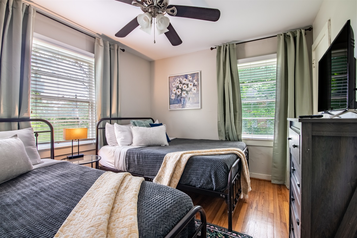 Charming twin bedroom with a warm, inviting vibe and ample natural light.