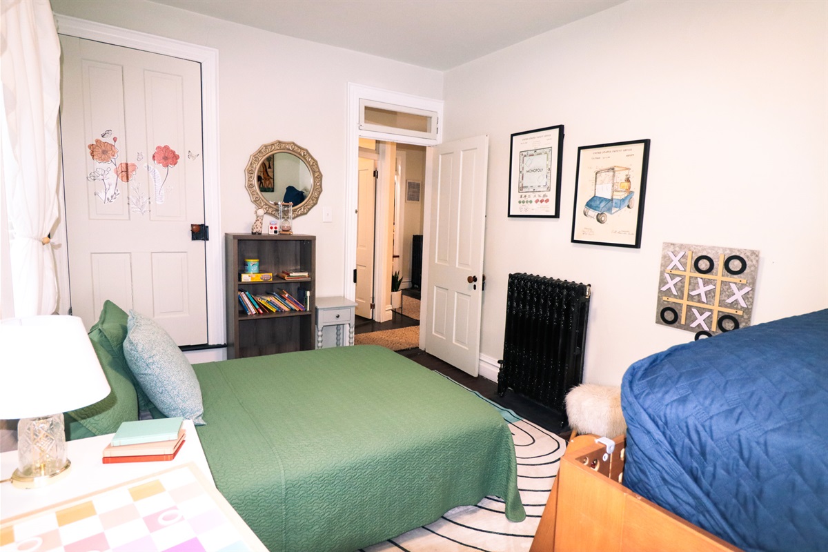 Sun filled family bedroom with full size bed, bunk beds, and fun artwork