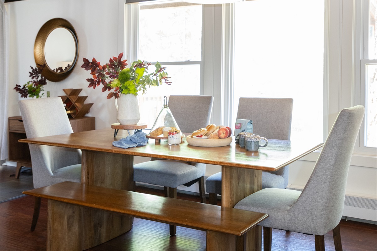 Gather Around the Table – The dining area offers seating for seven, with a mix of chairs and a rustic bench, creating a welcoming and casual setting.  
