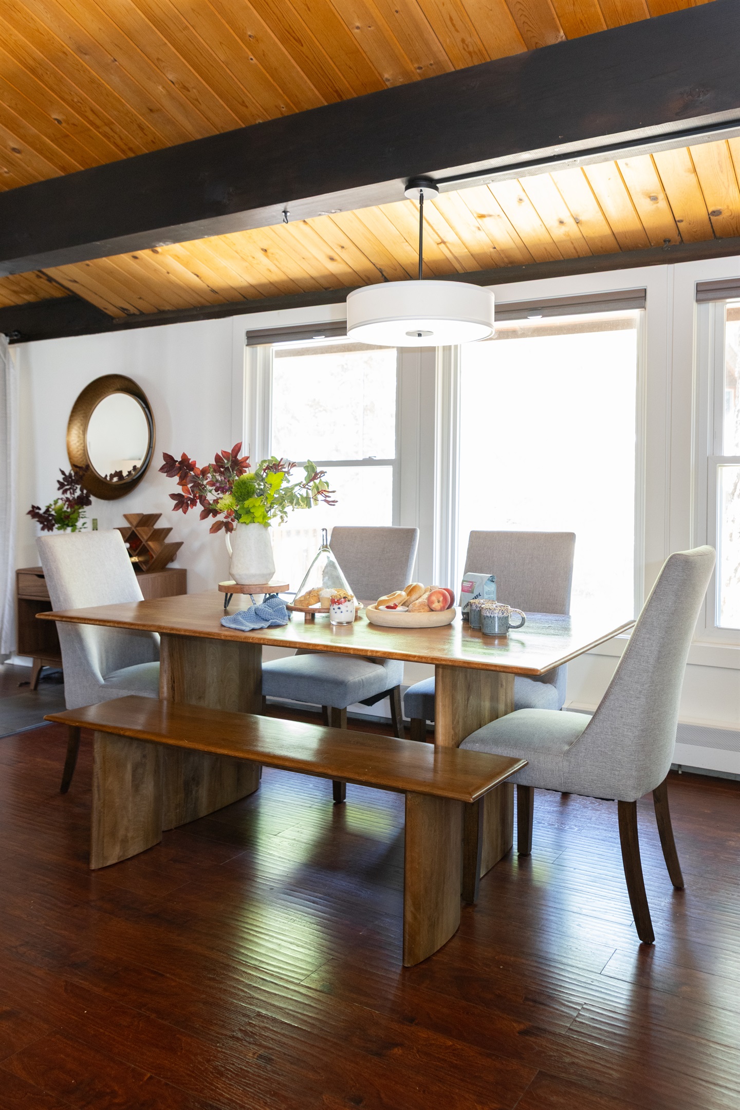 Gather Around the Table – The dining area offers seating for seven, with a mix of chairs and a rustic bench, creating a welcoming and casual setting.  
