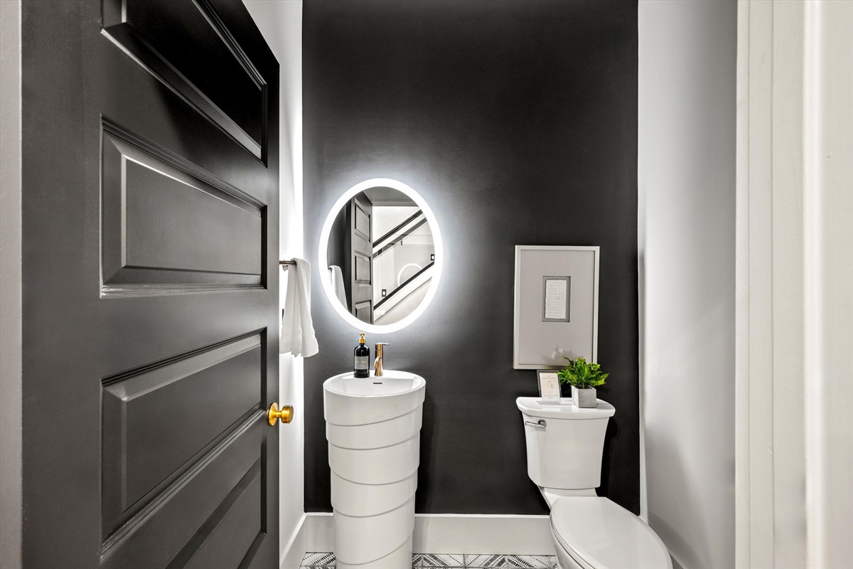 A well-appointed half-bathroom featuring a toilet and vanity for added convenience during your stay.