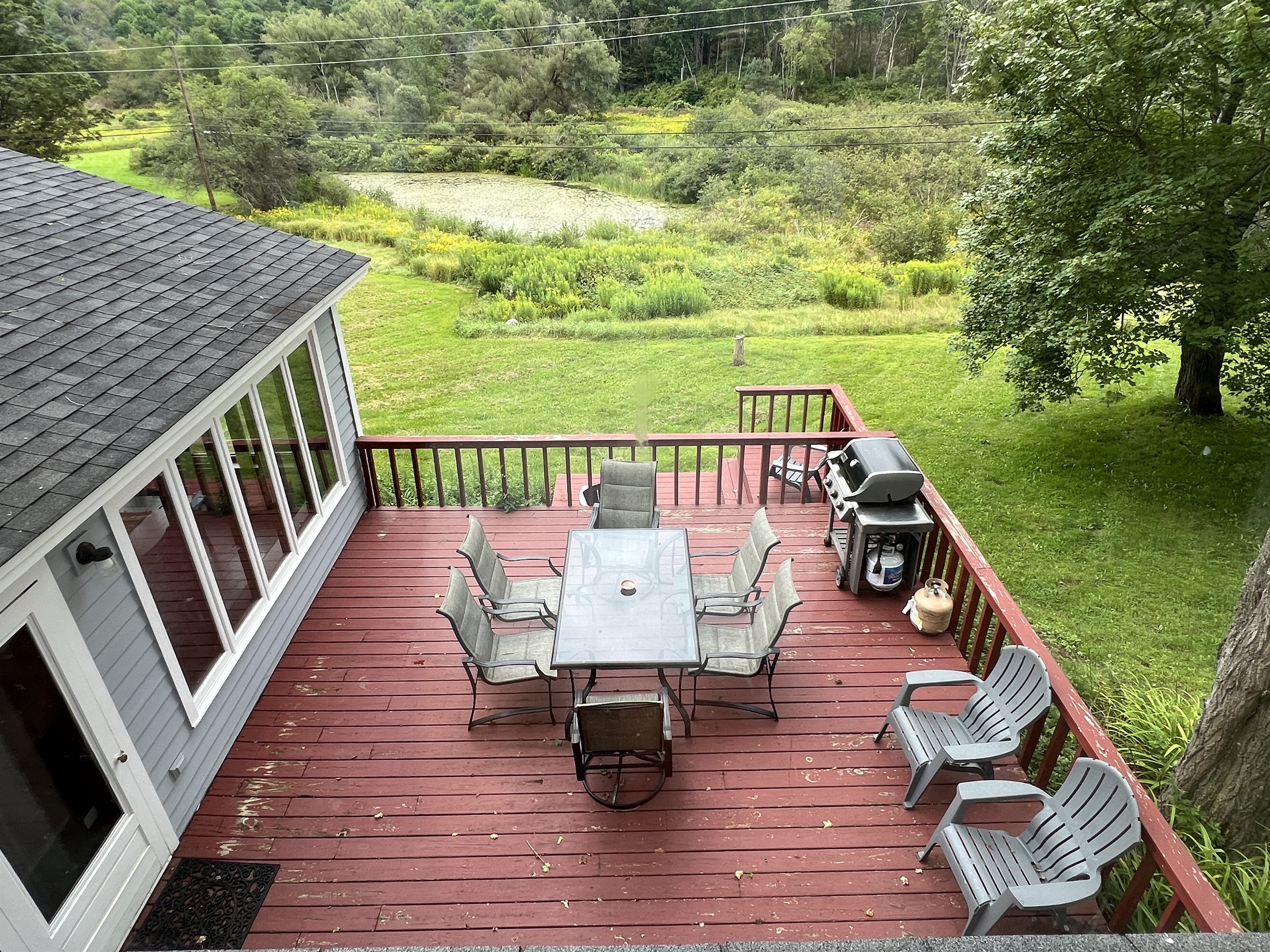 Cloverleaf Farm 2nd floor bedroom #3 view looking down onto the deck and the pond from the large picture window.