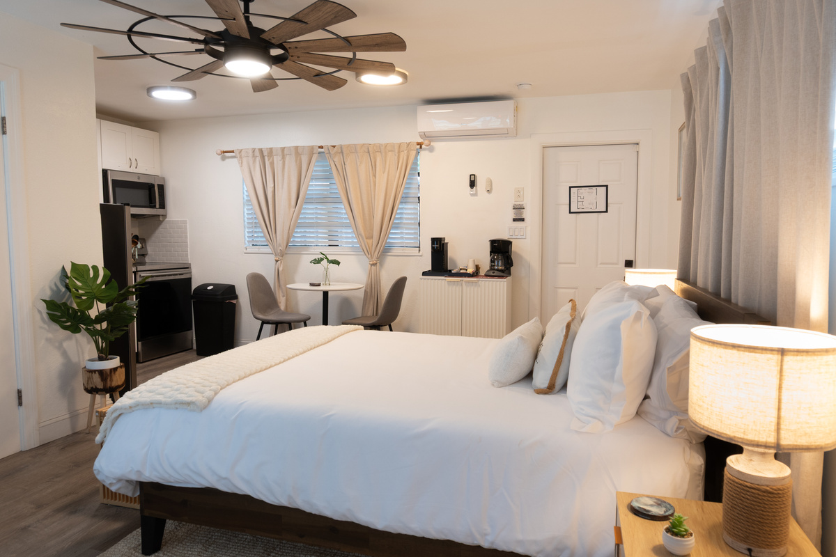Open studio layout: bed, dining table and full kitchen in one bright space