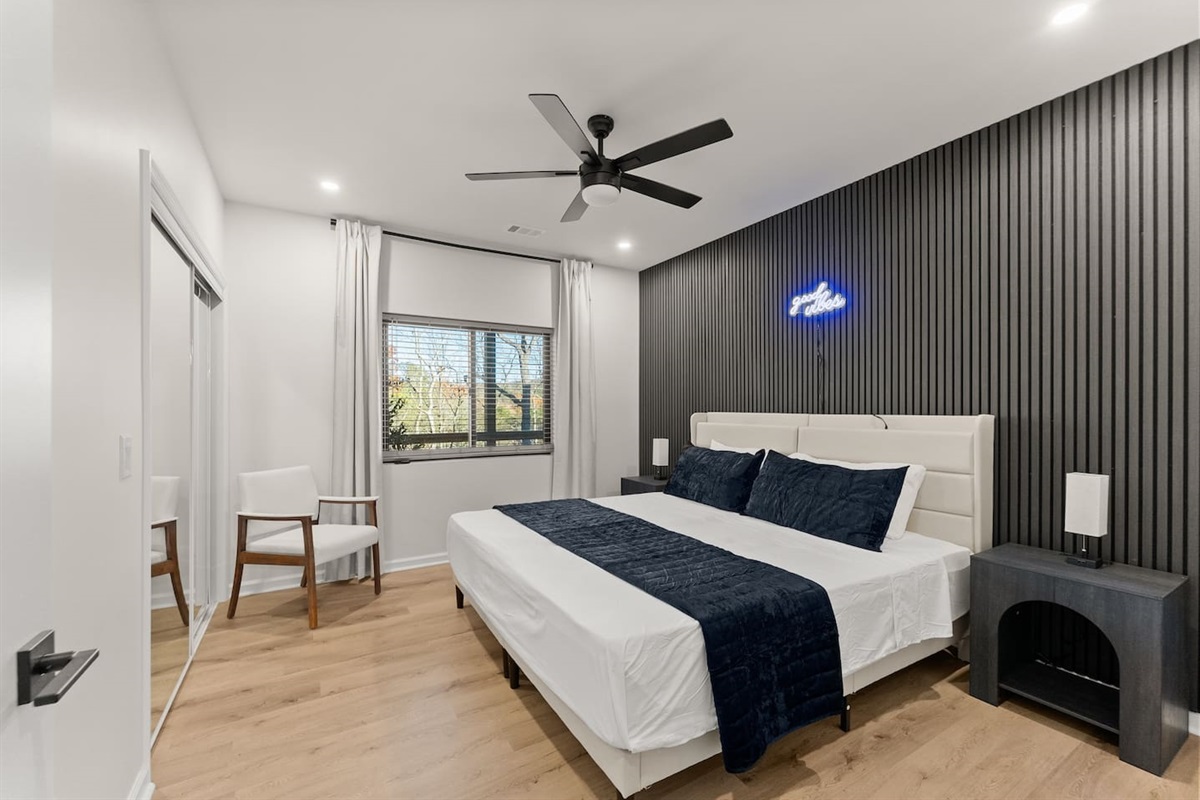 Another stylish bedroom with two flexible twin beds that can convert into a king, complete with modern nightstands, wall panels, and a spacious closet—perfect for families or guests.