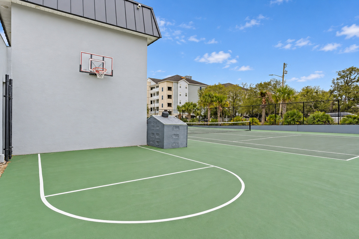 Shared sports court with basketball hoop and tennis court access for outdoor play during the stay.