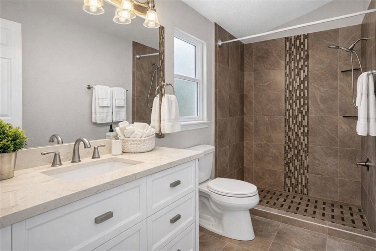 Master bathroom featuring a walk-in tiled shower and modern vanity.