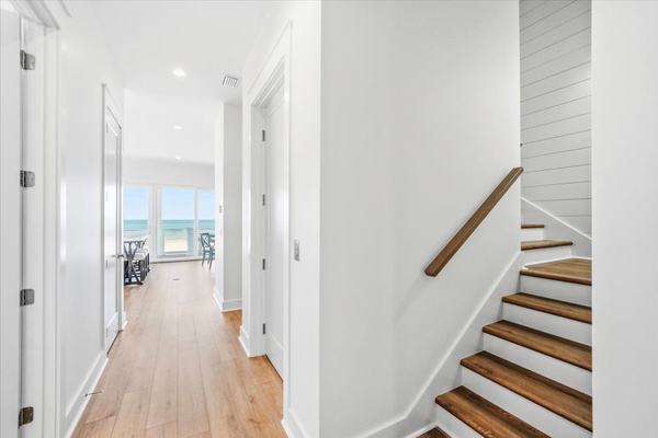 The stairs or elevator can take you to the middle floor which features a rec room, deck with stairs down to the pool, a kitchenette, a king bedroom, a bedroom with 2 double beds, and a bedroom with 4 twin beds (2 bunk beds)