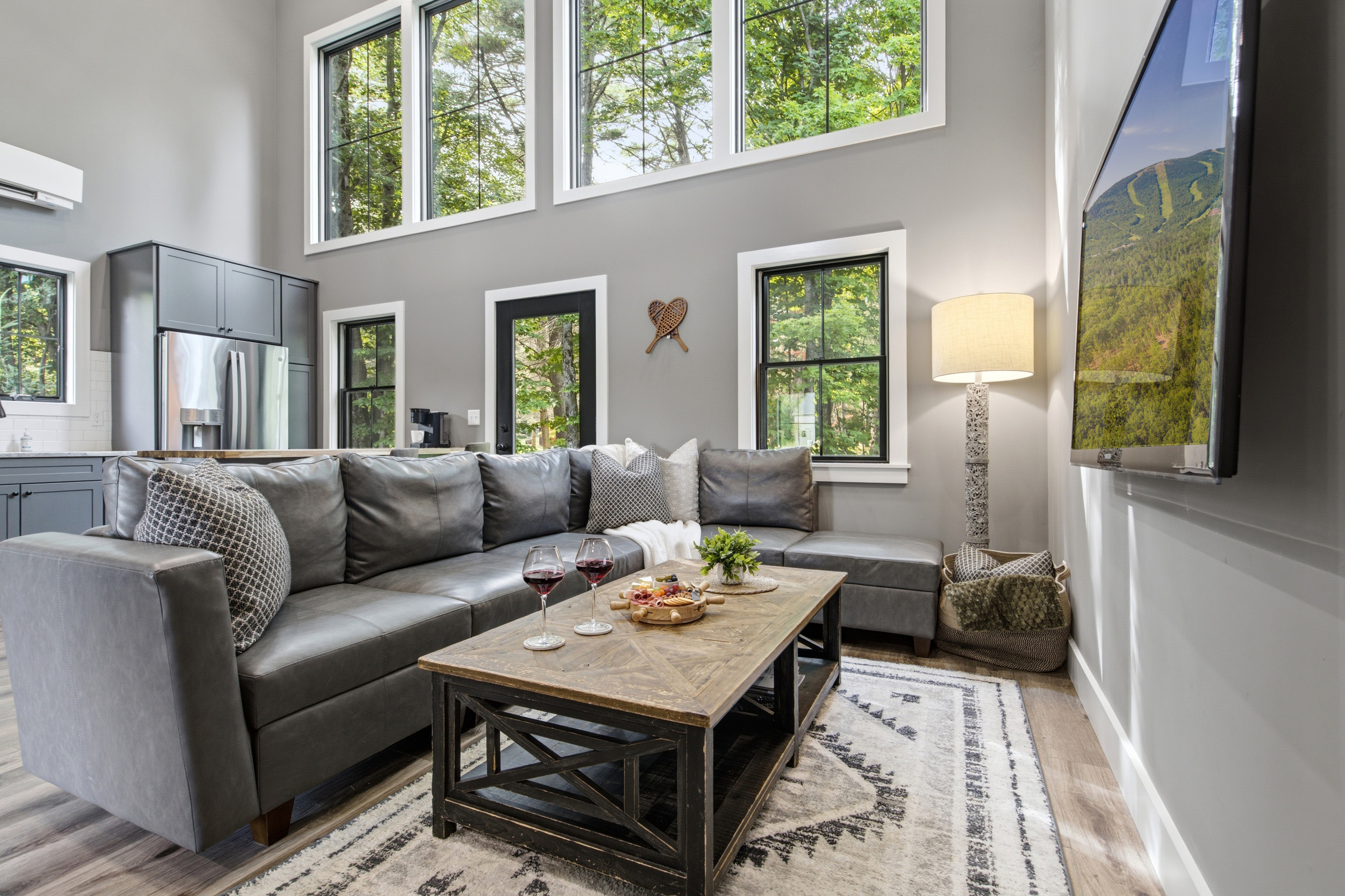 Gather together in a light-filled living space surrounded by peaceful wooded views.