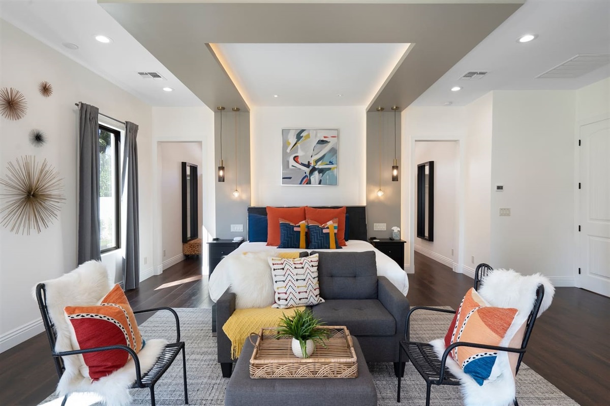 Step into your personal retreat! Our spacious bedroom with a chic mini living area, colorful pillows, and one-of-a-kind design offers the perfect blend of relaxation and flair.