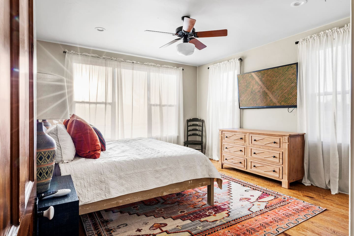 Master bedroom features a king bed, TV and attached ensuite full bathroom, clawfoot soaking tub, walk-in shower