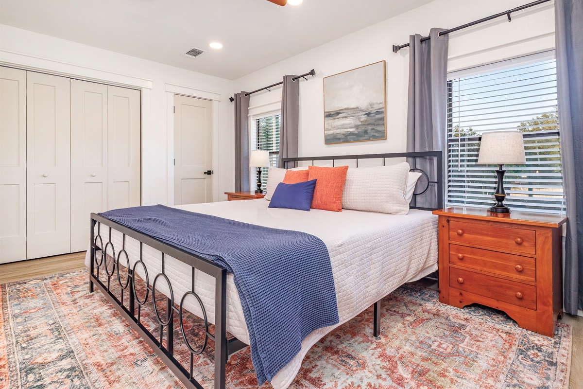 Downstairs master bedroom with a plush king bed, cozy linens, and plenty of storage for a comfortable stay.