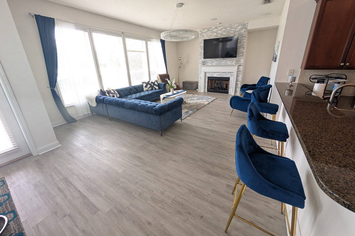 Open-concept living space with a large sectional, fireplace, TV, and seating right off the kitchen.