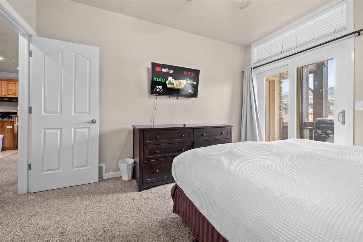 Primary bedroom retreat with TV, cozy bedding, and peaceful ambiance.