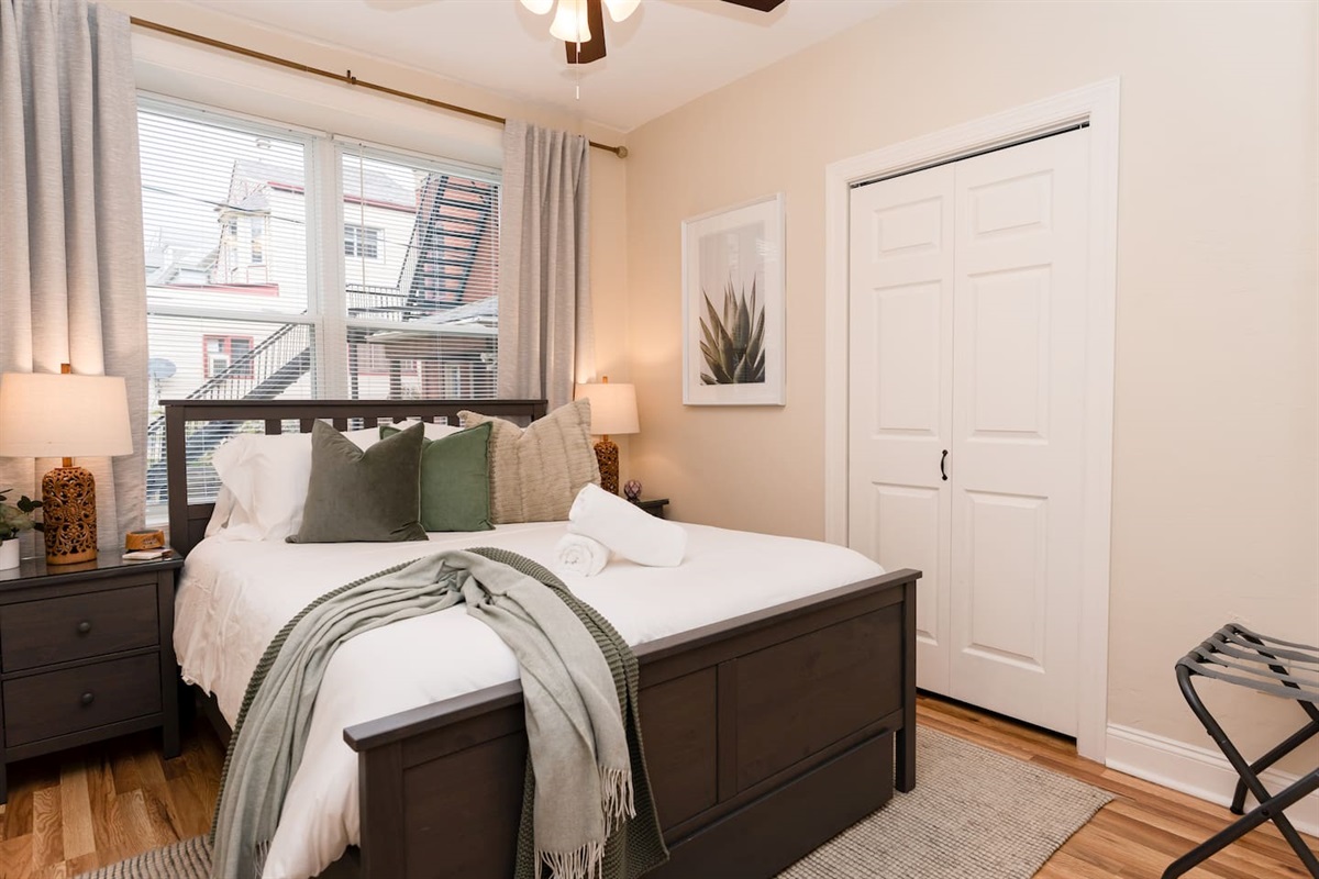 Queen-sized bed with a window, providing a bright and comfortable space to relax.