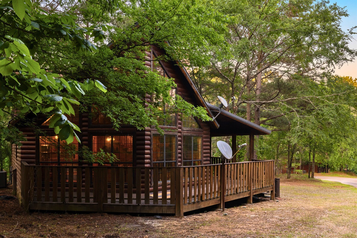 Front view of the cabin surrounded by trees.
