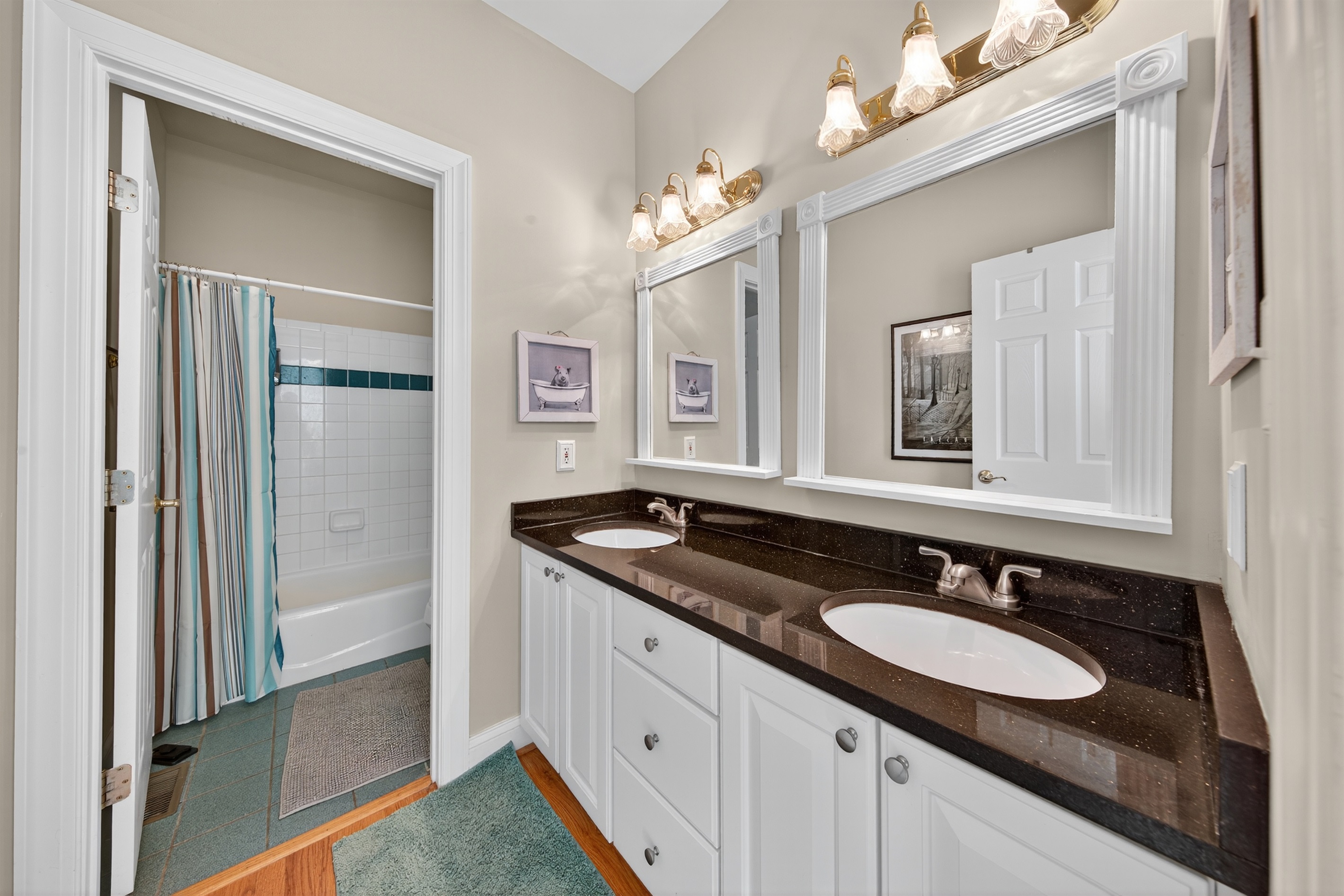Shared bathroom with dual vanities and tub/shower combo.