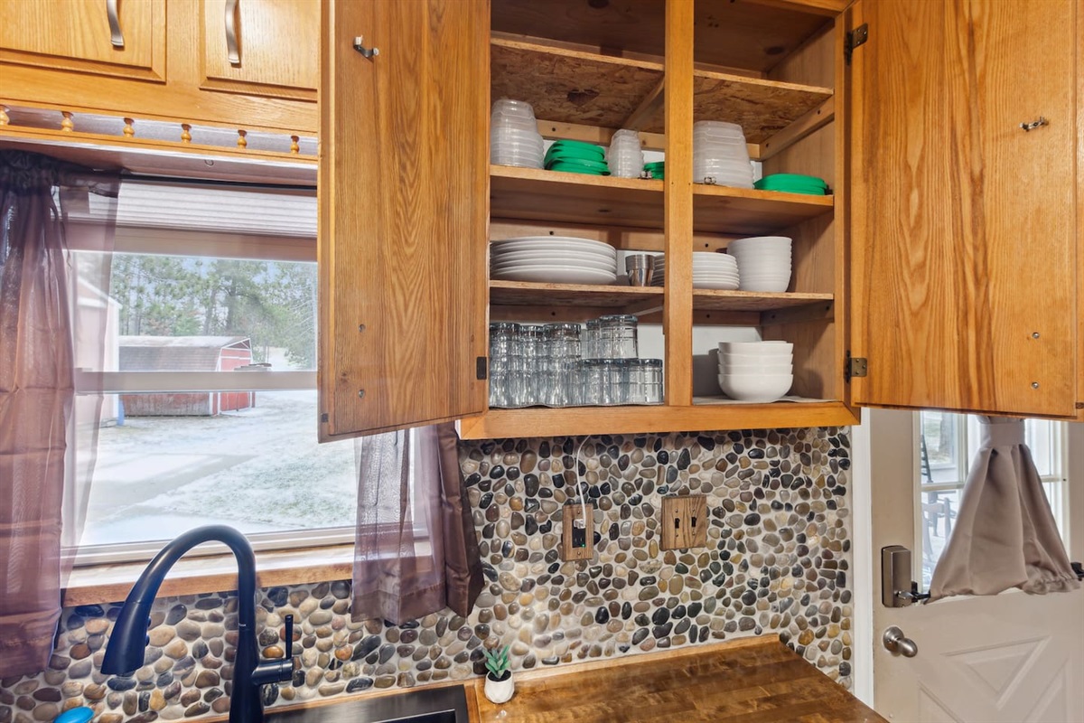 Plenty of dishes for 8 people, as well as utensils located in kitchen island drawers. Tupperware with lids for food you'd like to save.