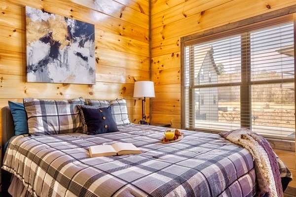 Plush mattress with luxurious bedding, cozy pillows, and soft throws—perfect for curling up with a good book and a warm drink as natural light pours in from the window.