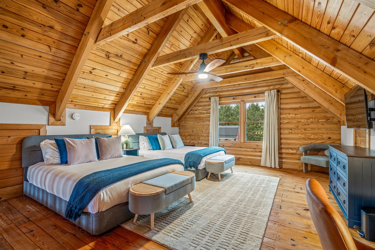 This roomy loft suite offers a warm cabin feel with soaring wood ceilings, multiple queen beds, and lots of open space perfect for groups traveling together.