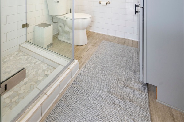 Bathroom 2 (Downstairs) is a Bright, modern bathroom with a walk-in glass shower and fresh, spa-like finishes