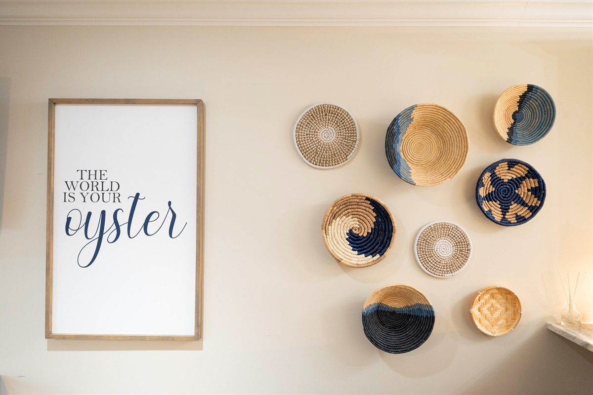 "The world is your oyster" wall art with woven baskets creates an inspiring home decor vibe.