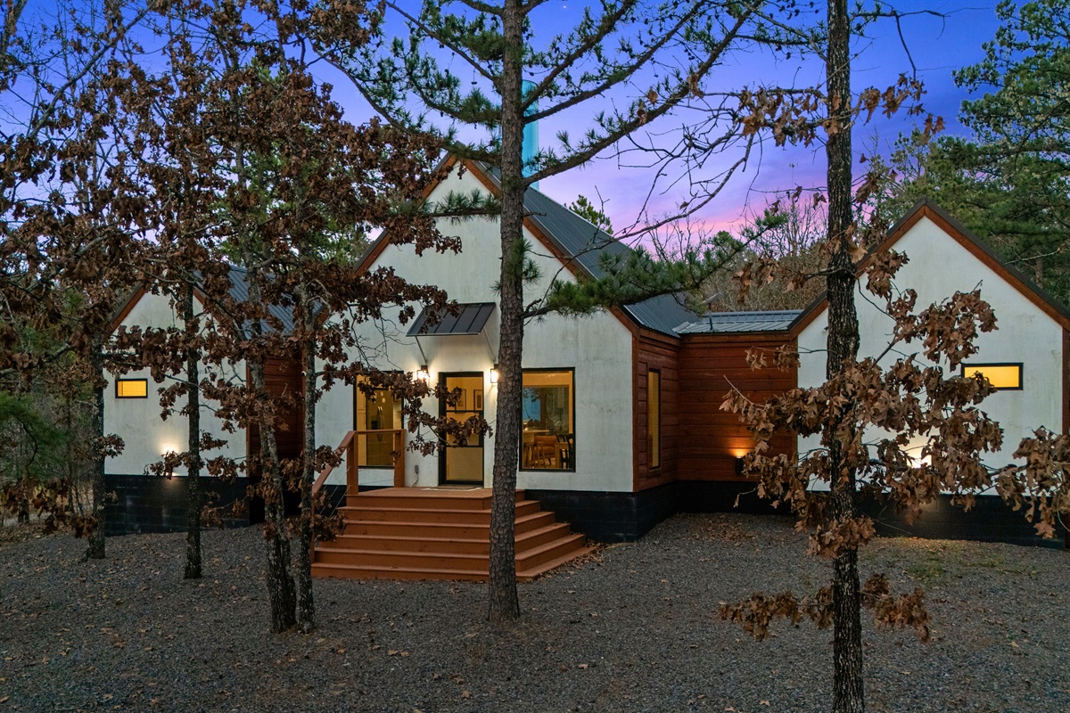 A welcoming front porch and warm exterior lighting make arriving here feel like stepping into your own private mountain getaway.