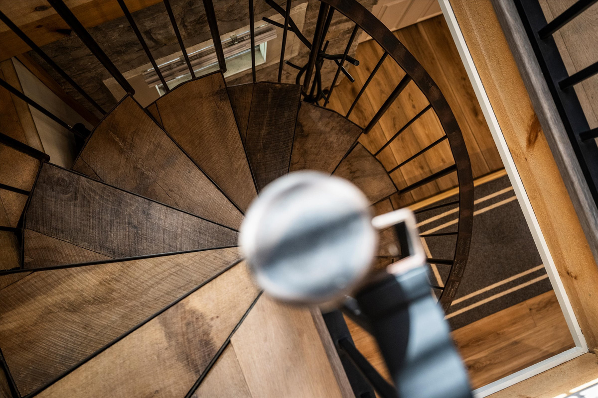 Spiral Stairs to go to the lower level where King Bed and desk are located.