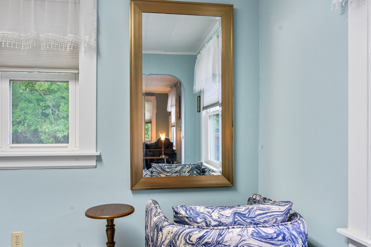 This den room view highlights our extra vanity space layout, complete with a comfortable accent chair and full length wall mirror. Ideal for applying makeup and getting ready, this setup helps relieve bathroom congestion during your Maine group stay.
