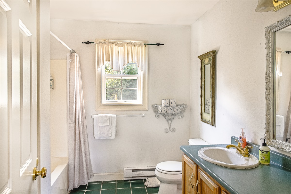 The spacious upstairs guest bathroom features a full tub and shower combination, perfect for soaking after a day on the trails. With classic finishes and plenty of natural light, it provides a bright, refreshing space for the whole family.