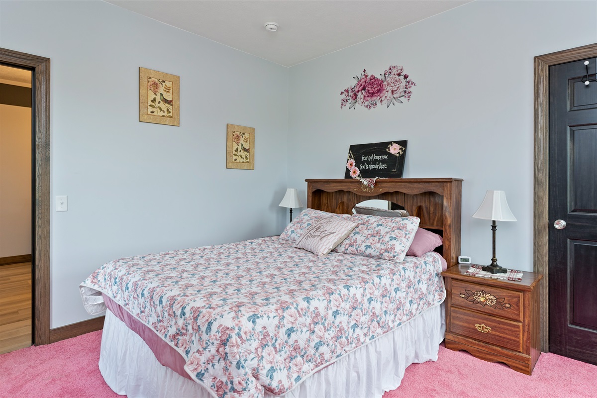 Peaceful Queen bedroom retreat with floral bedding, elegant wood furniture, and delicate wall art creating a warm, restful ambiance. Bedroom #2