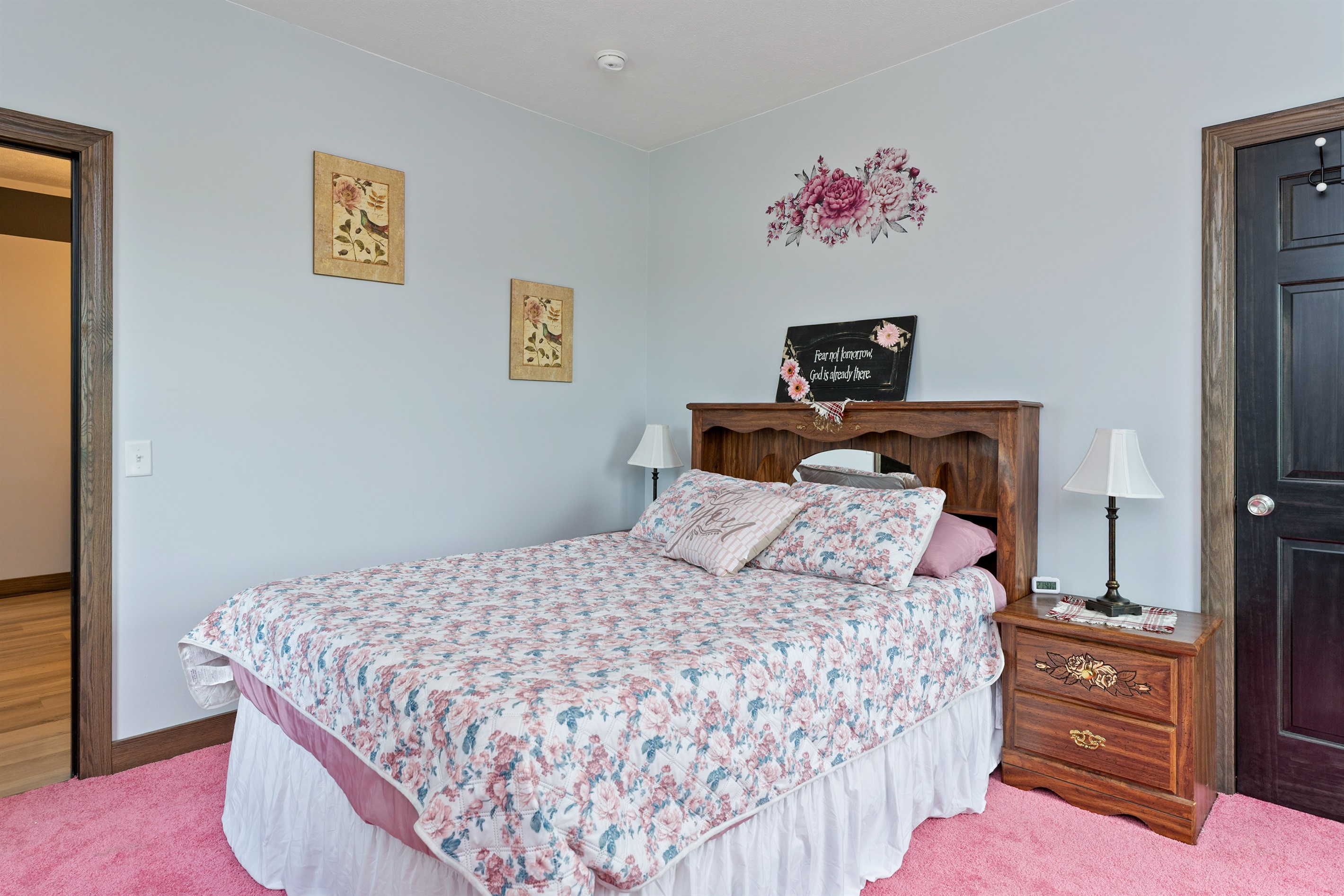 Peaceful Queen bedroom retreat with floral bedding, elegant wood furniture, and delicate wall art creating a warm, restful ambiance. Bedroom #2