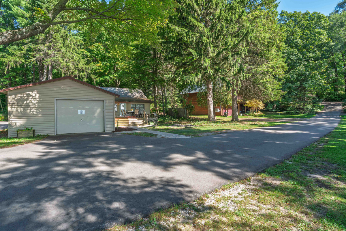 The cottage sits on a small private road, with its lakefront lawn and dock directly across the road.