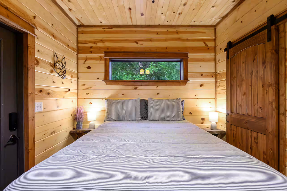 Bedroom: Relax in this charming retreat with natural wood tones and picturesque forest views!