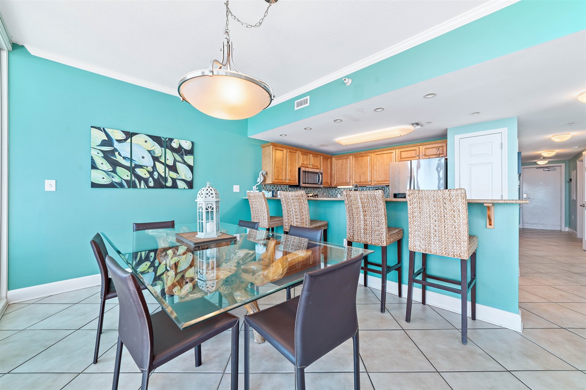 Dine in style with ample space for everyone. This inviting dining area features a charming table for family meals, complemented by additional seating at the convenient breakfast bar.