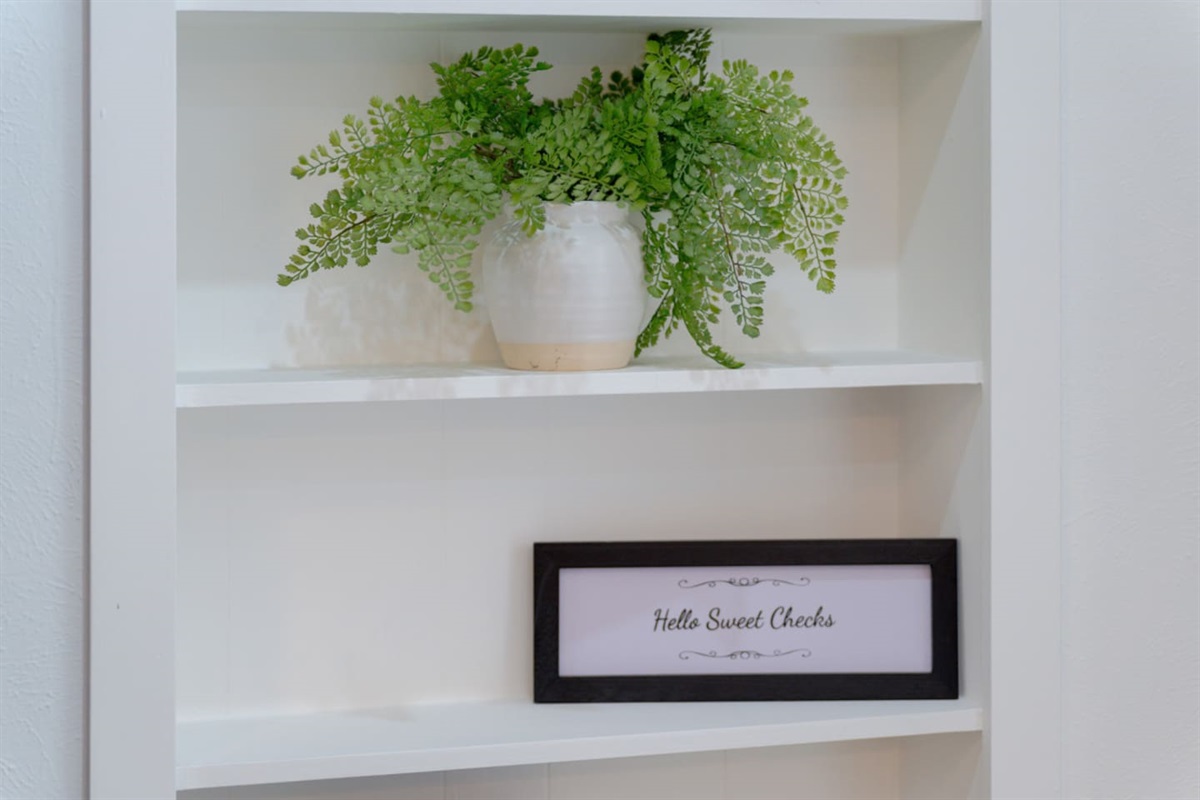 Built-in shelving styled with greenery and modern accents.
