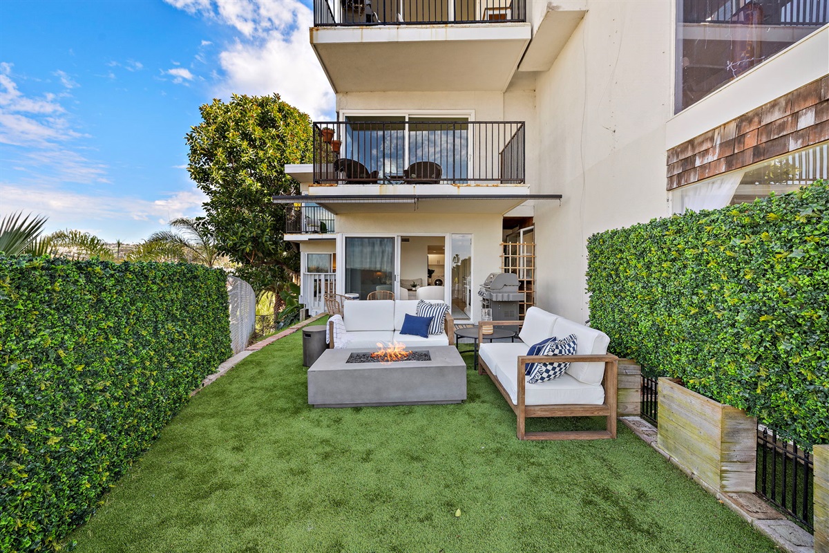 Spacious private outdoor lounge with comfortable seating, manicured greenery, and plenty of room to relax—your own peaceful retreat just steps from the living space
