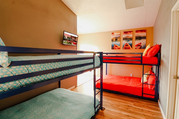 A room featuring a bunk bed and a strategically placed TV, ensuring a comfortable viewing experience without compromising on space.