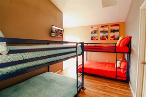 A room featuring a bunk bed and a strategically placed TV, ensuring a comfortable viewing experience without compromising on space.