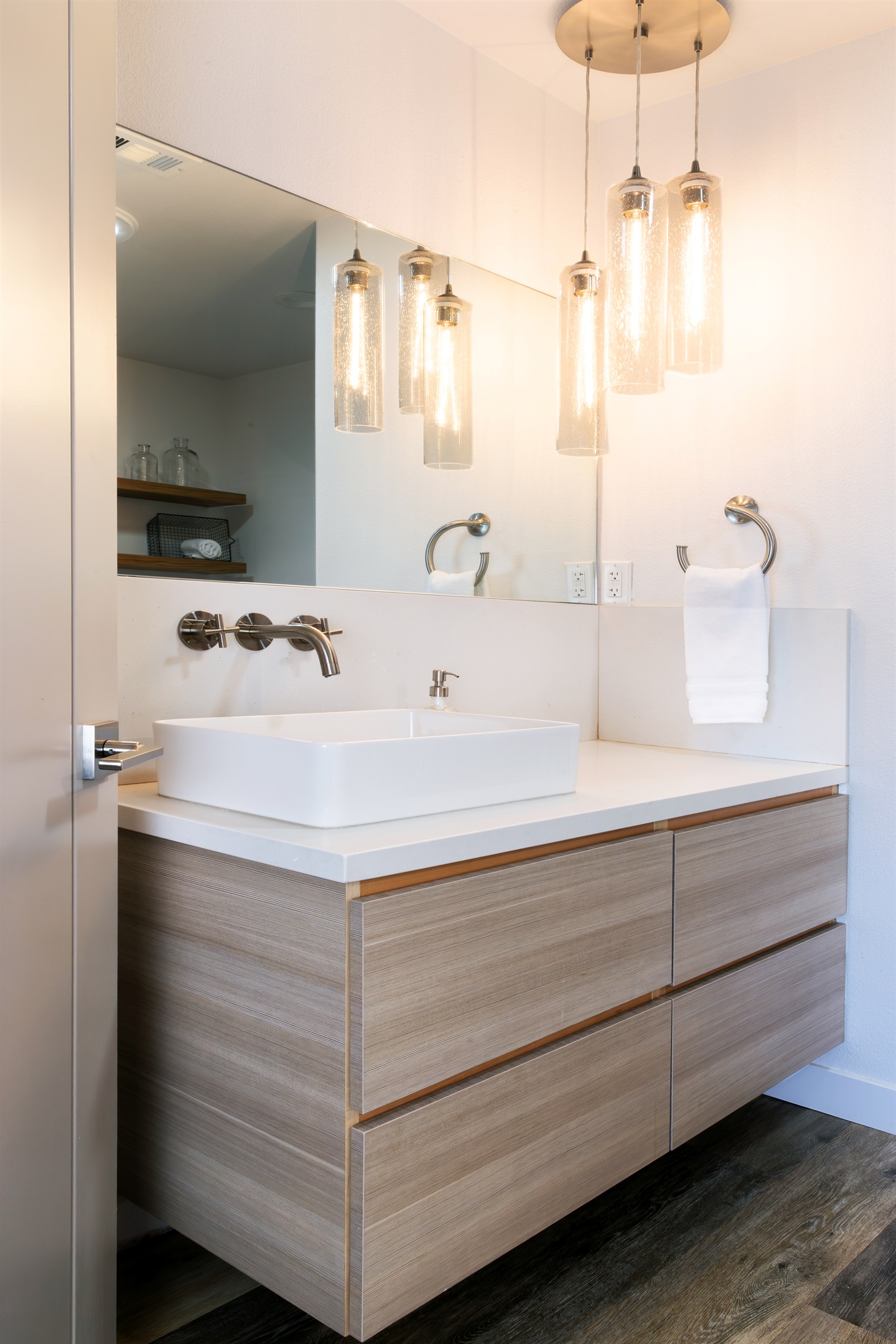 A stunning vessel sink and cascading glass pendant lights set the tone for mornings that feel anything but ordinary.