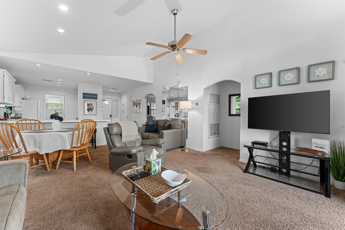 Wide living-room view showing the easy connection between lounge space, dining area, and kitchen.