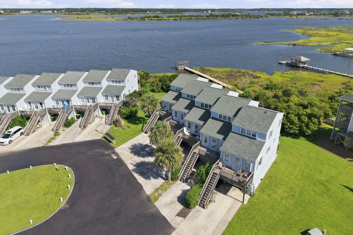 A picturesque look at the neighborhood's inviting design, featuring private staircases and lush green lawns.