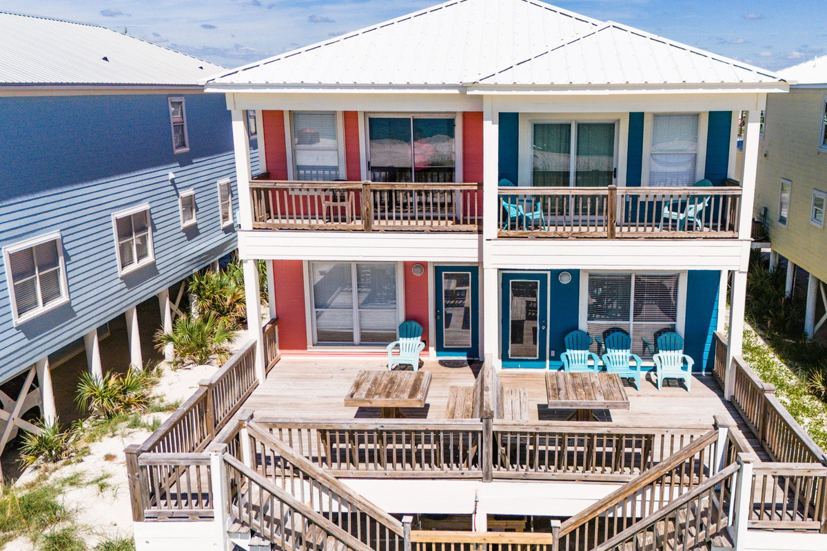 Aerial view of the coastal vacation home showcasing the private outdoor pool, spacious deck, and colorful beach house design.